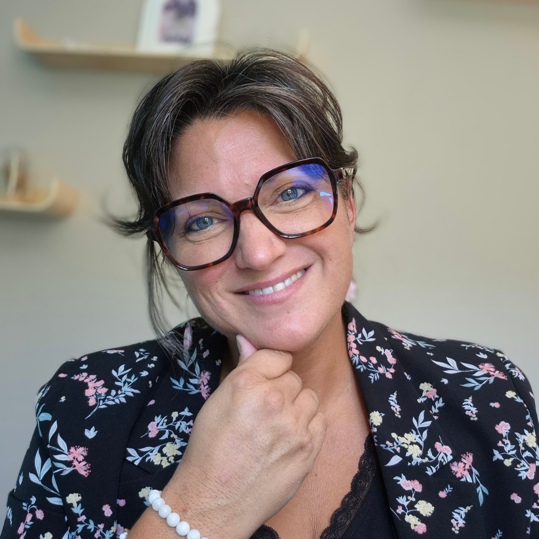 Céline Mauguen, souriante, avec ses lunettes et une veste à fleurs